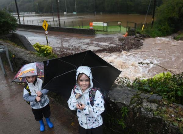 Alys and Zac Lane were well wrapped up as they inspected the damaged road and flooded Sarsfields GAA Club pitch in the wake of Storm Babet. Picture: Eddie O'Hare Alys and Zac Lane were well wrapped up as they inspected the damaged road and flooded Sarsfields GAA Club pitch in the wake of Storm Babet. Picture: Eddie O'Hare